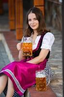 Sexy russian woman in Bavarian dress holding beer mugs. photo