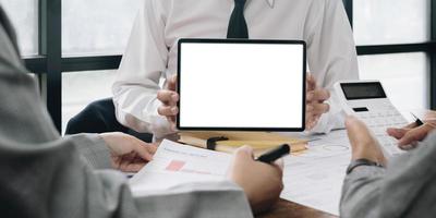 Close up of business team working analysis brainstorm together tablet blank white screen placed at office. Mock up. photo