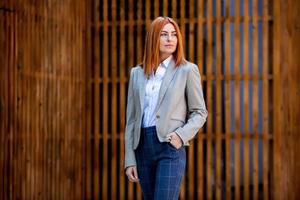 experto en negocios confiado. profesional exitoso feliz posando cerca del edificio de oficinas. chica europea. dama de negocios rusa. concepto de líder empresarial femenino. retrato de mujer de negocios exitosa foto