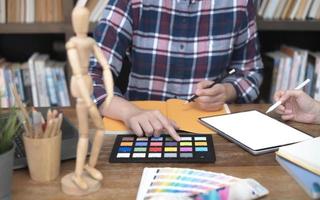 Two artists working on tablet, colour paper tone on workspace at the office photo