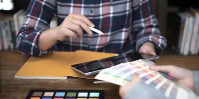 Two artists working on tablet, colour paper tone on workspace at the office photo