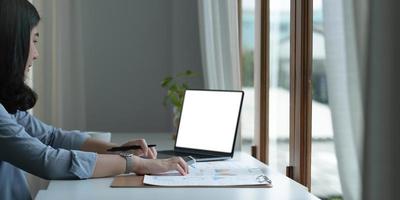 Woman working on laptop mock-up with blank copy space screen photo