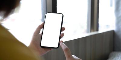 Young Asian woman using smartphone white screen at coffee shop. technology and bussiness concept background. photo