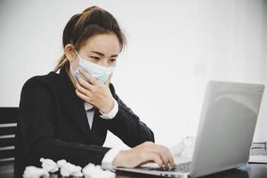 mujer de negocios asiática joven enferma con mascarilla protectora foto