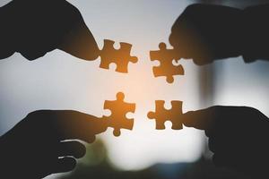 hand of business people connecting jigsaw puzzle photo
