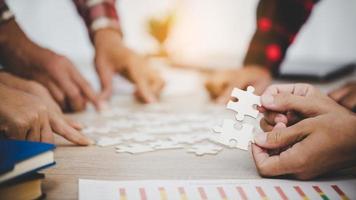 Business people and puzzle on wooden table photo