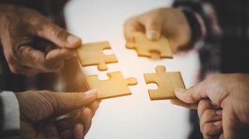 Hands holding piece of blank jigsaw puzzle for teamwork photo