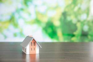 small model house with green bokeh background photo