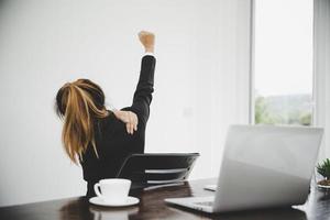 Young asian woman are tired from work, sit in a chair, stretch photo