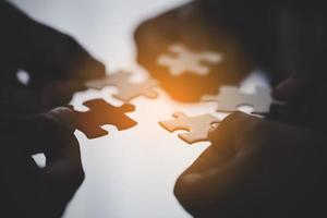 Hands holding piece of blank jigsaw puzzle for teamwork photo