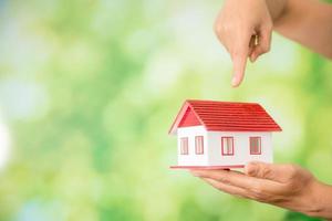 small model house with green bokeh background photo