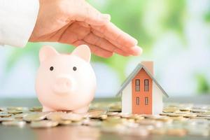 Model house with piggy bank and coins money photo