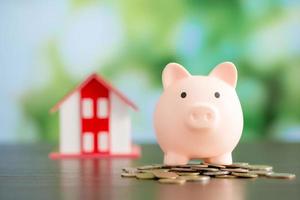 Model house with piggy bank and coins money photo
