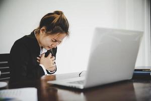 mujer de negocios asiática con traje negro estaba enferma de dolor en el pecho foto