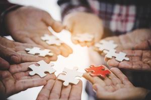 Hands holding piece of blank jigsaw puzzle for teamwork photo