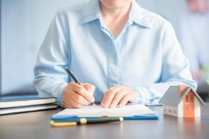 Close up of hand of the real estate agent drafting an agreement photo