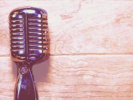 Vintage style classic microphone placed on an old wood. photo