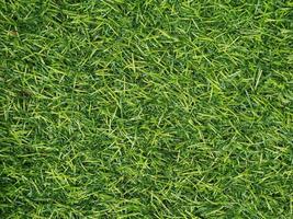 Texture of bright green artificial grass can use for background and design. photo