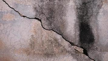 The old cement wall was weathered, the surface was scratched, the surface was scratched and damaged. For a mysterious retro-conservative background. photo