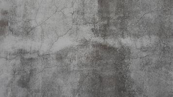The old cement wall was weathered, the surface was scratched, the surface was scratched and damaged. For a mysterious retro-conservative background. photo