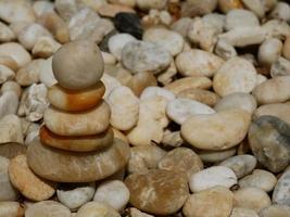 The Balance Stones are stacked as pyramids in a soft natural bokeh background, representing the calm philosophical concept of Jainism's wellness. photo