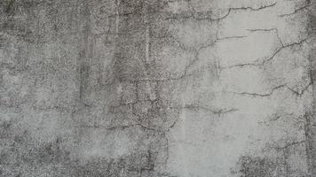 The old cement wall was weathered, the surface was scratched, the surface was scratched and damaged. For a mysterious retro-conservative background. photo