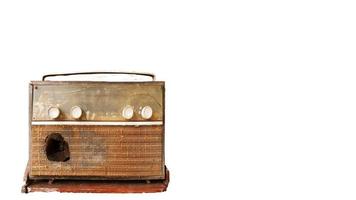 A very old, damaged radio player with an old picture background. photo