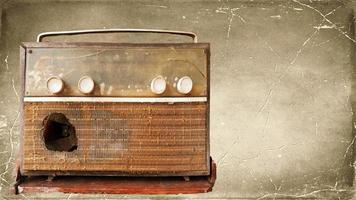 A very old, damaged radio player with an old picture background. photo