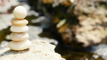 las piedras de equilibrio se apilan como pirámides en un suave fondo bokeh natural, lo que representa el tranquilo concepto filosófico del bienestar del jainismo. foto