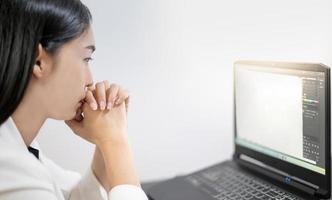 jóvenes asiáticos que sienten estrés por el trabajo, mientras están sentados frente a la computadora portátil en su casa. foto