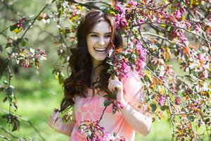 beautiful white european girl with clean skin in the park with flowering trees photo