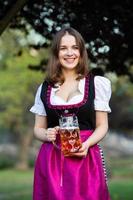 Sexy russian woman in Bavarian dress holding beer mugs. photo