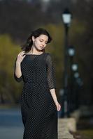 Woman's portrait with a hair moving in the wind. Close-up portrait of young beautiful Russian brunette girl at summer green park. European white woman in dress. photo