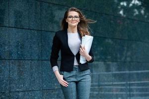 experto en negocios confiado. profesional exitoso feliz posando cerca del edificio de oficinas. chica europea. dama de negocios rusa. concepto de líder empresarial femenino. retrato de mujer de negocios exitosa foto