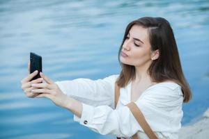 Girl outdoors texting on her mobile phone. Girl with phone. Portrait of a happy woman text sms message on her phone. photo