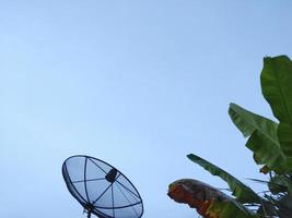 black satellite dish on the roof of the house  overcast sky  On a day with inclement weather photo