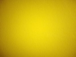 Background of plaster wall painted in yellow, vignette, vintage style. photo