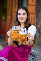 Sexy russian woman in Bavarian dress holding beer mugs. photo