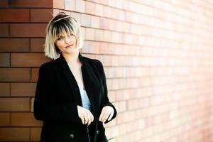 experto en negocios confiado. profesional exitoso feliz posando cerca del edificio de oficinas. chica europea. dama de negocios rusa. concepto de líder empresarial femenino. retrato de mujer de negocios exitosa foto