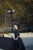 Woman's portrait with a hair moving in the wind. Close-up portrait of young beautiful Russian brunette girl at summer green park. European white woman in dress. photo