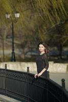 retrato de mujer con un cabello moviéndose en el viento. primer plano retrato de joven hermosa chica morena rusa en el parque verde de verano. mujer blanca europea vestida. foto