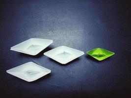 white and green paper boat On the black background, vignette, vintage style, concept, leadership, and management. photo