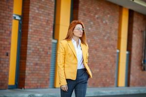 experto en negocios confiado. profesional exitoso feliz posando cerca del edificio de oficinas. chica europea. dama de negocios rusa. concepto de líder empresarial femenino. retrato de mujer de negocios exitosa foto