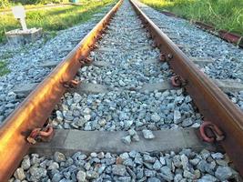 The rusted orange rails were firmly clinging to the gray stone surface. photo