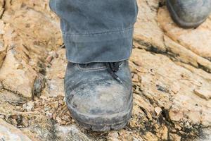 bota de cuero trekking en la roca foto