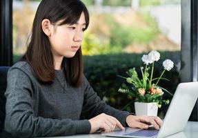 Teenage student using laptop doing homework at home photo