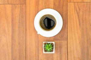 White cup of coffee on wood background photo