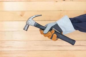 Hand in glove holding hammer photo