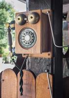 Vintage telephone hang on wooden pole photo