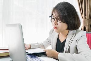 Woman teenage working on laptop in home office photo